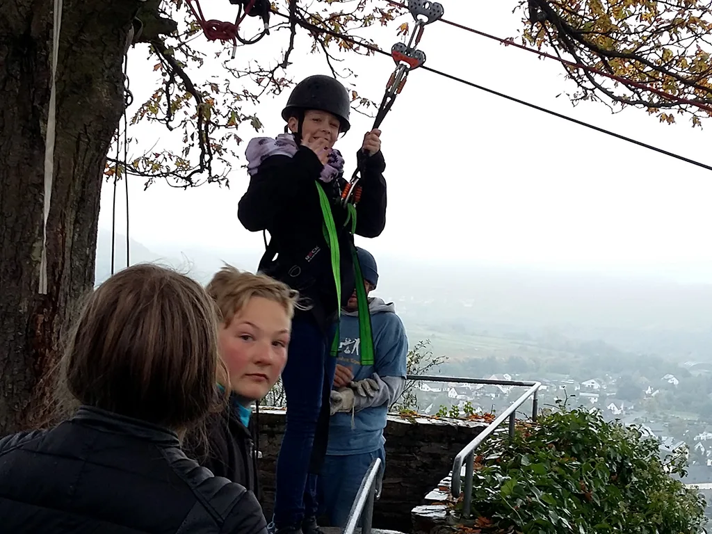 Person startet mit Helm in die Seilrutsche.